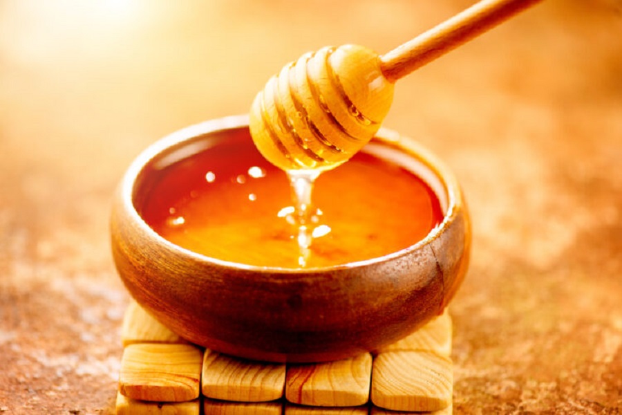 Honey,Dripping,From,Honey,Dipper,In,Wooden,Bowl.,Close-up.,Healthy