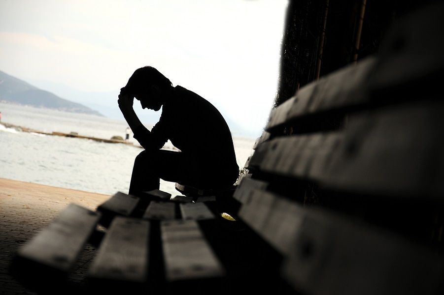 depressed young man sitting on the bench